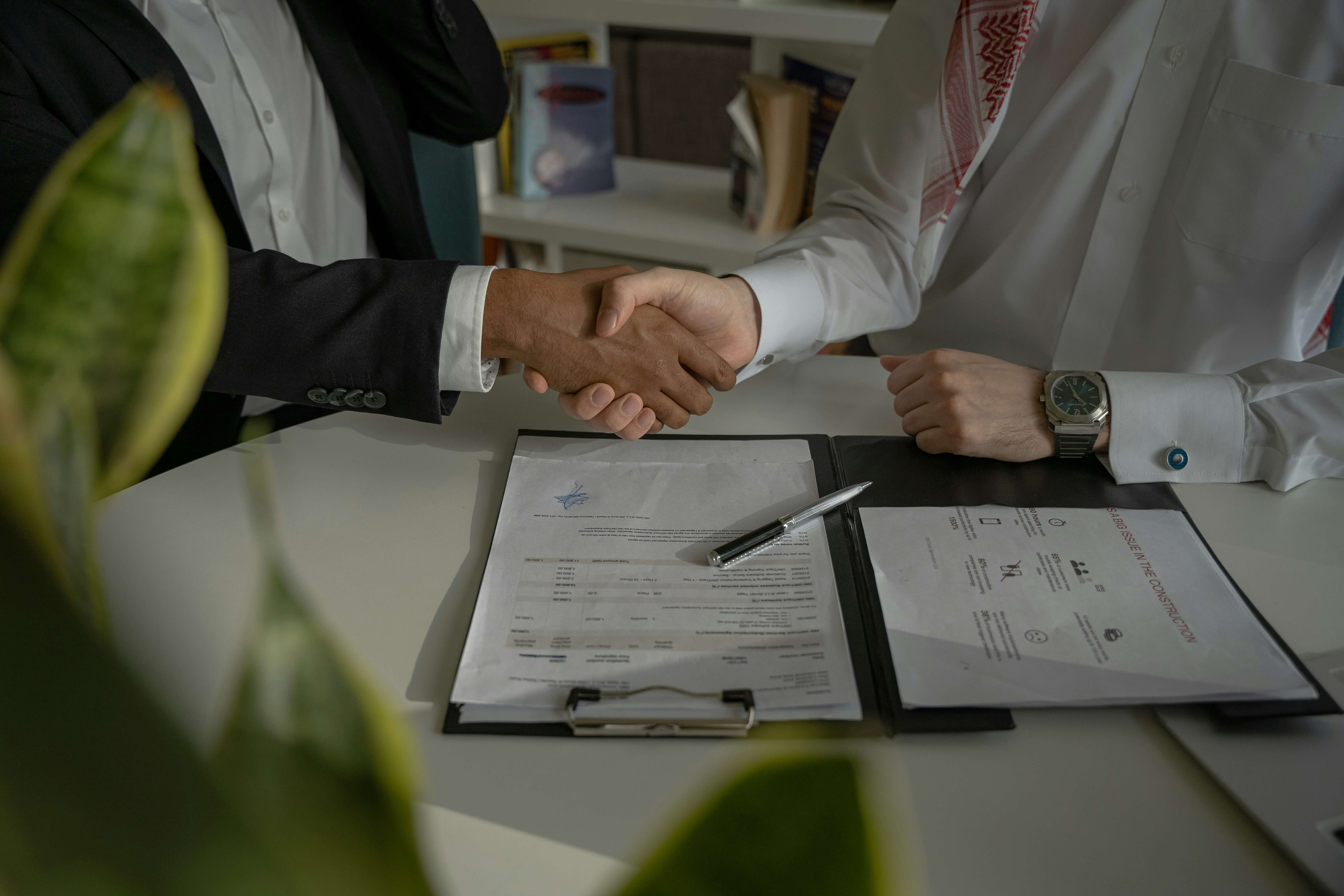 Étape Suivi et renégociation — poignée de main devant un contrat